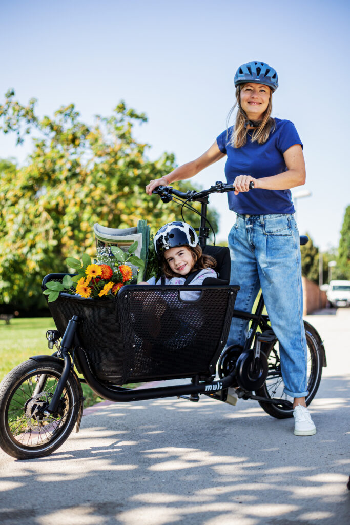 Frau mit Kind im Lastenrad